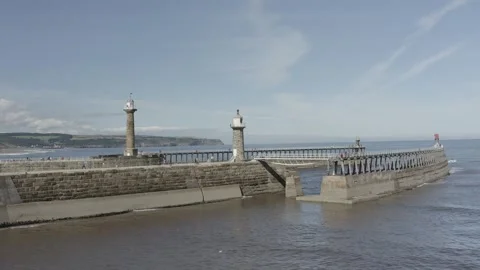 Whitby piers drone shot low flying backwards towards land Stock Footage 240633935
