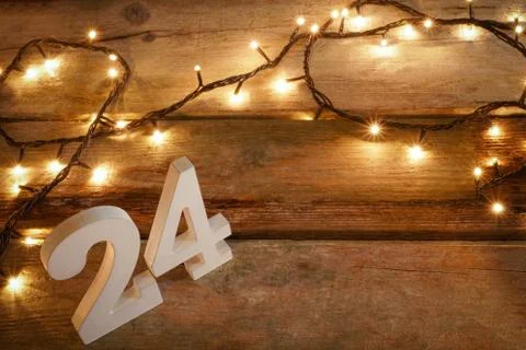 White 24 letter blocks in rustic wooden table with yellow Christmas lights. With Stock Photos
