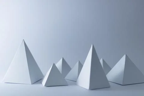 White 3d handmade pyramids on white background, selective focus Stock Illustration