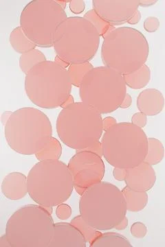 White abstract background with flying pink plastic circles, pattern, top view Illustrazione stock