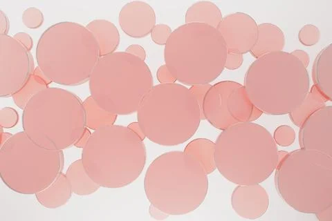 White abstract background with flying pink plastic circles, pattern, top view 写真素材