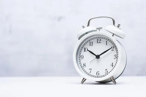 White alarm clock on a clean light background with large copy space. Concep.. Stock Photos
