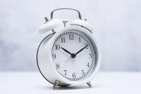 White alarm clock on a clean light background with large copy space. Concep.. Stock Photos