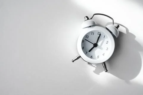  white alarm clock on a light background close-up Stock Photos