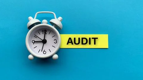 White alarm clock with text Audit sticky note. Audit time concept 스톡 사진