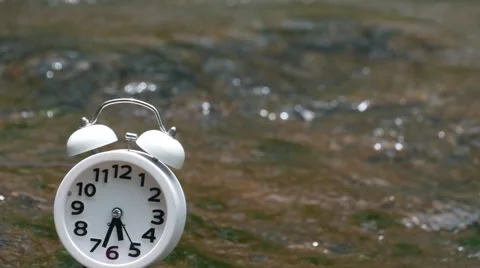 White alarm clock on waterfall background soft focus, 스톡 동영상 66381437