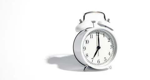 White alarm clock on a white background isolated, close-up. Stock Photos