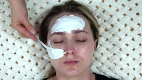 A white alginate mask is applied to a woman to rejuvenate her skin. Stock Footage 144646853