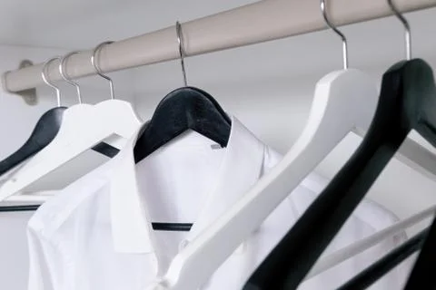 White and black empty clothes hangers, in the wardrobe Foto stock