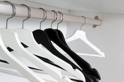 White and black empty clothes hangers, in the wardrobe Foto stock