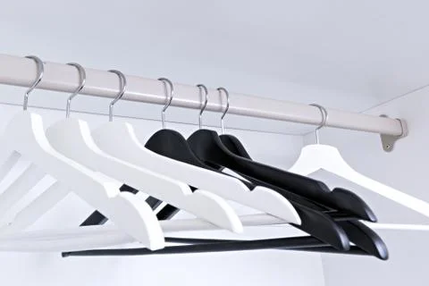 White and black empty clothes hangers, in the wardrobe Stock-Fotos
