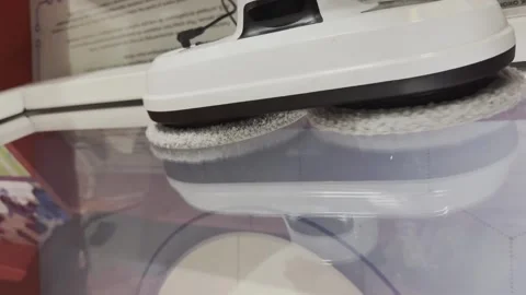A white and black robot is cleaning a toilet bowl Stock Footage 279823488