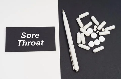 On a white and black surface are pills, a pen and a sign with the inscription Stock Photos