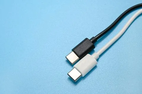 White and Black USB Type-C charger cable on a blue background. Stock Photos