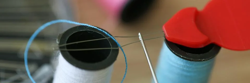 White and blue coils of threads and sewing equipment Stock Photos