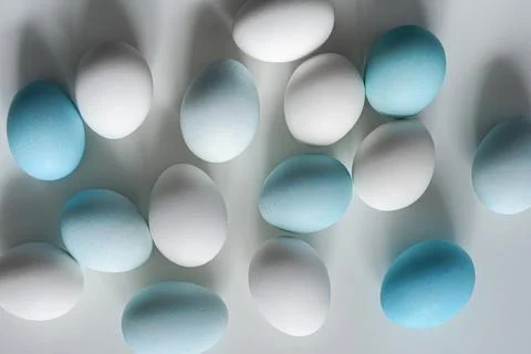 White and blue Easter eggs on white table Top view Stock Photos