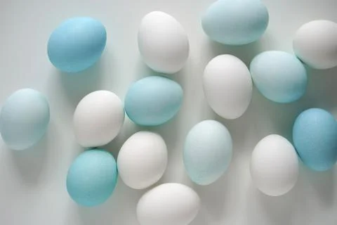 White and blue Easter eggs on white table Top view Stock Photos