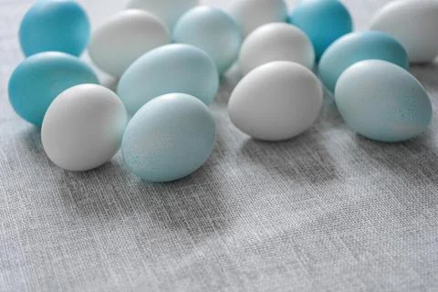 White and blue Easter eggs on grey linen cloth Stock Photos