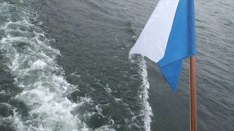 White and Blue Flag flying over a boats wake Video stock 84999969
