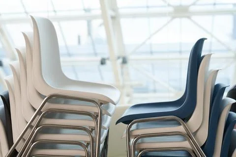 White and blue plastic chairs in a row are waiting for visitors. White plastic Stock-Fotos