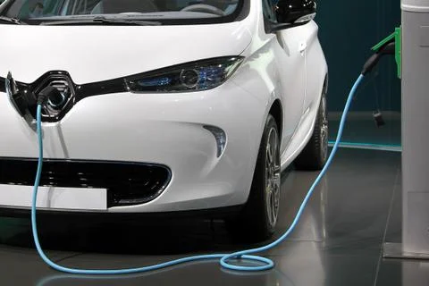 White and clean electric car charging in a garage. Stock Photos