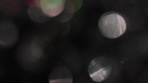 White and colored bokeh light penetrates the frames against a black background. Vídeos de archivo 317480939