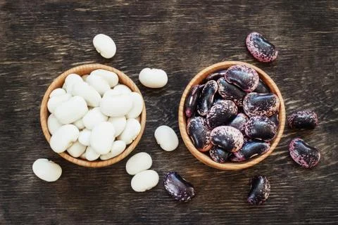 White and dark beans on a dark wooden background in a cup Stock Photos