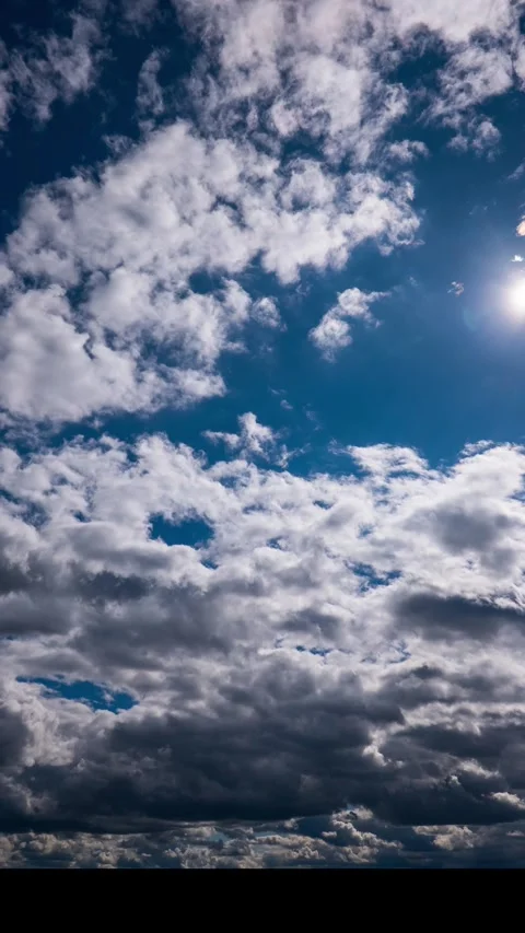 White and dark clouds drift rapidly across a deep blue sky in an accelerate.. 動画素材 337456591