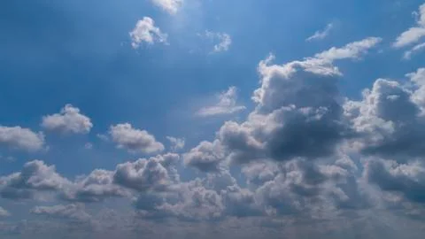 White and Dark Clouds Floating in the Bright Blue Skies Stock Photos