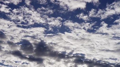 White and dark clouds moving across a blue sky Stock Footage 329756684