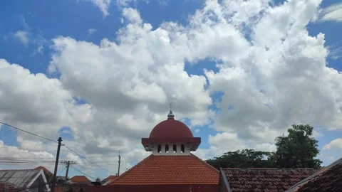 White and gray clouds blue sky with a view of the red mosque dome Stock Footage 274153270