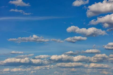 White and gray clouds float across the blue sky. Stock Photos