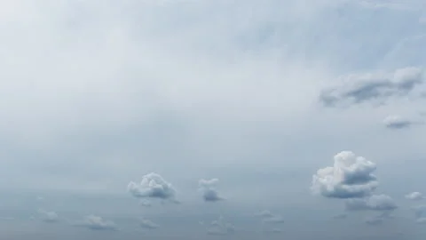 White and gray fluffy clouds moving softly on pale cloudy sky. Stock Footage 133903816