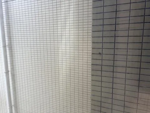 White and Gray Tiled Wall with Vertical Pipe Stock-Fotos