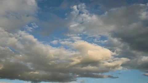 White and grey clouds with a hint of orange move slowly through an evening sky  Stock Footage 138662542