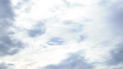White and light gray clouds moving across a pale blue sky, with diffused su.. Stock Footage 348235276