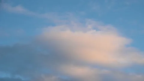 White and pink clouds move through a light blue sky. Stock Footage 146385104