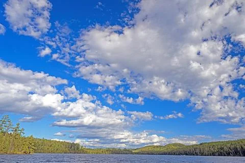 White and Puffy Clouds Over a Remote Lake Stockfoto's