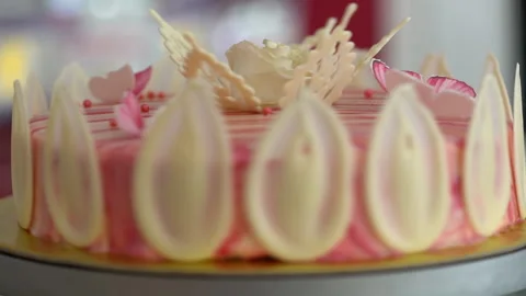 A white and red biscuit cake is sold by spinning in a display case Stock Footage 234825541