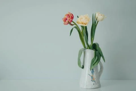 White and red spring tulips in a vase on a table. Mock up for displaying works Stock Photos
