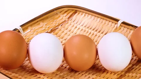 White and reddish-brown eggs lined up in a row, rotating Stock Footage 323575079