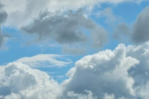White and thunderclouds in the blue sky. Stock Photos