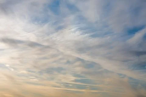 White and yellow clouds float across the sky, feather clouds, the sun is nearing 写真素材