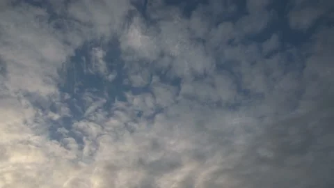 White and yellow fluffy clouds move through a blue sky.  Stock Footage 146905680
