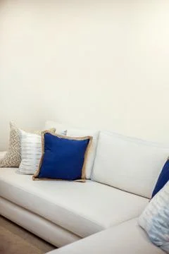 A white angled sofa with cushions Stock Photos