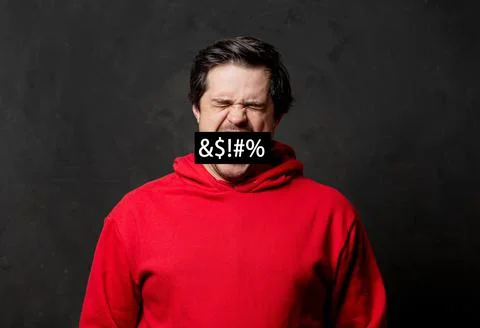 White angry guy in red sweatshirt on dark background Stock Photos