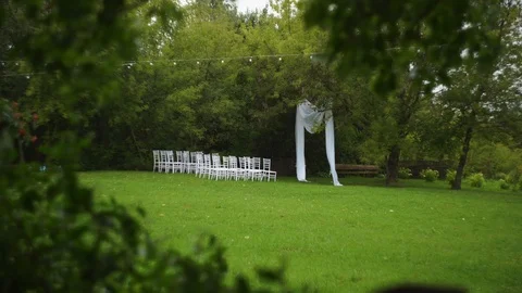 White arch and chairs for the wedding ceremony, green grass Stock Footage 122276288