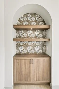 White arched wall opening features two light wooden shelves 库存插图