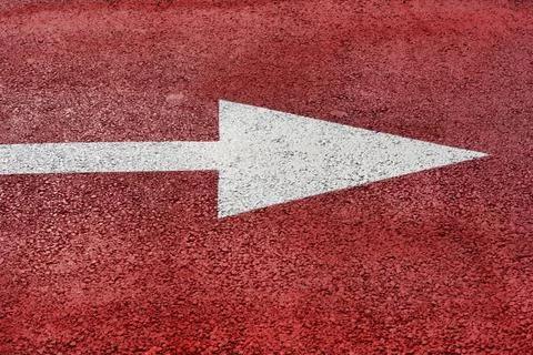 White arrow marking on red bicycle lane asphalt Stock Photos