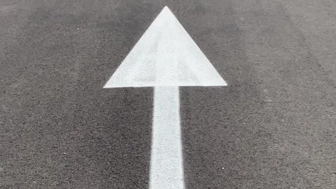 White arrow painted on asphalt road pointing forward. Concept of business and Stock Footage 341108940